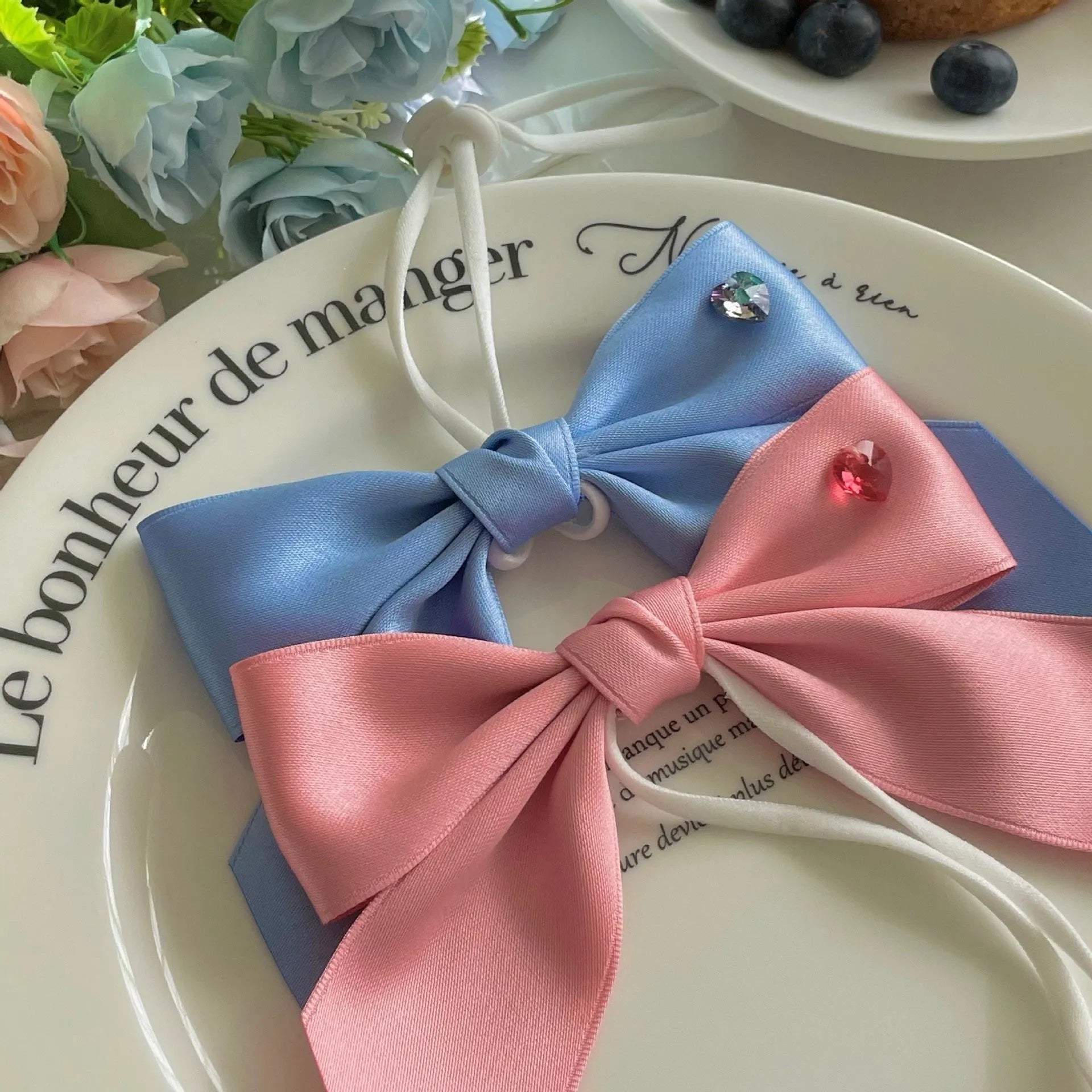 Blue princess-style bow dog hair band with adjustable tension on a model.