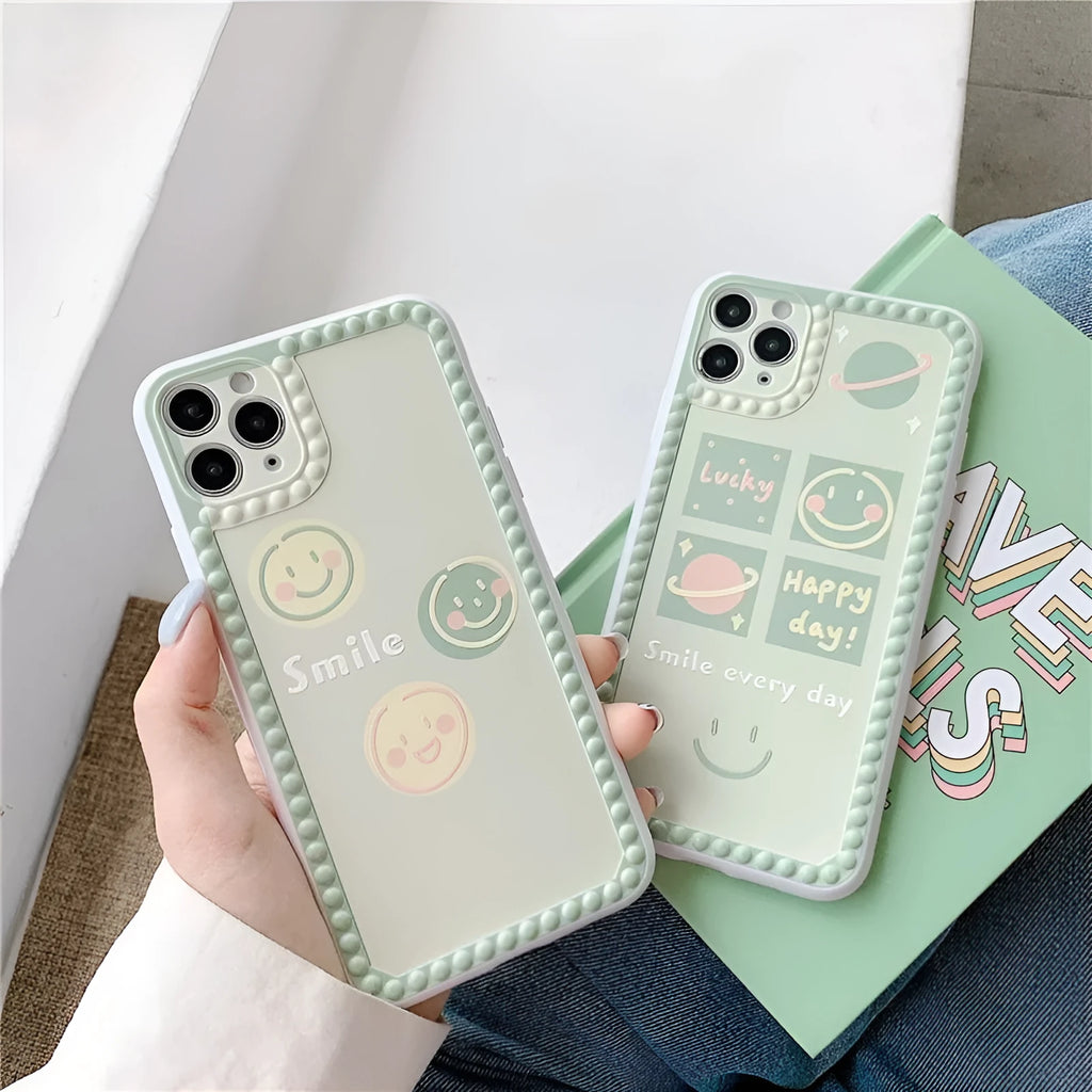Green TPU iPhone case with geometric smiley face design and polka dot frame on a phone.