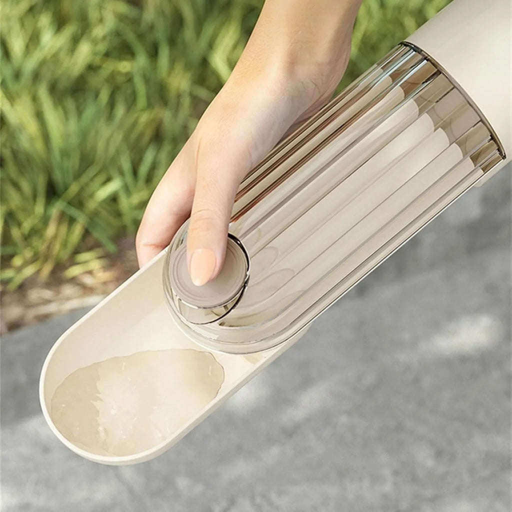 Beige and green foldable dog water bottle with food container, shown with press-to-dispense tray.