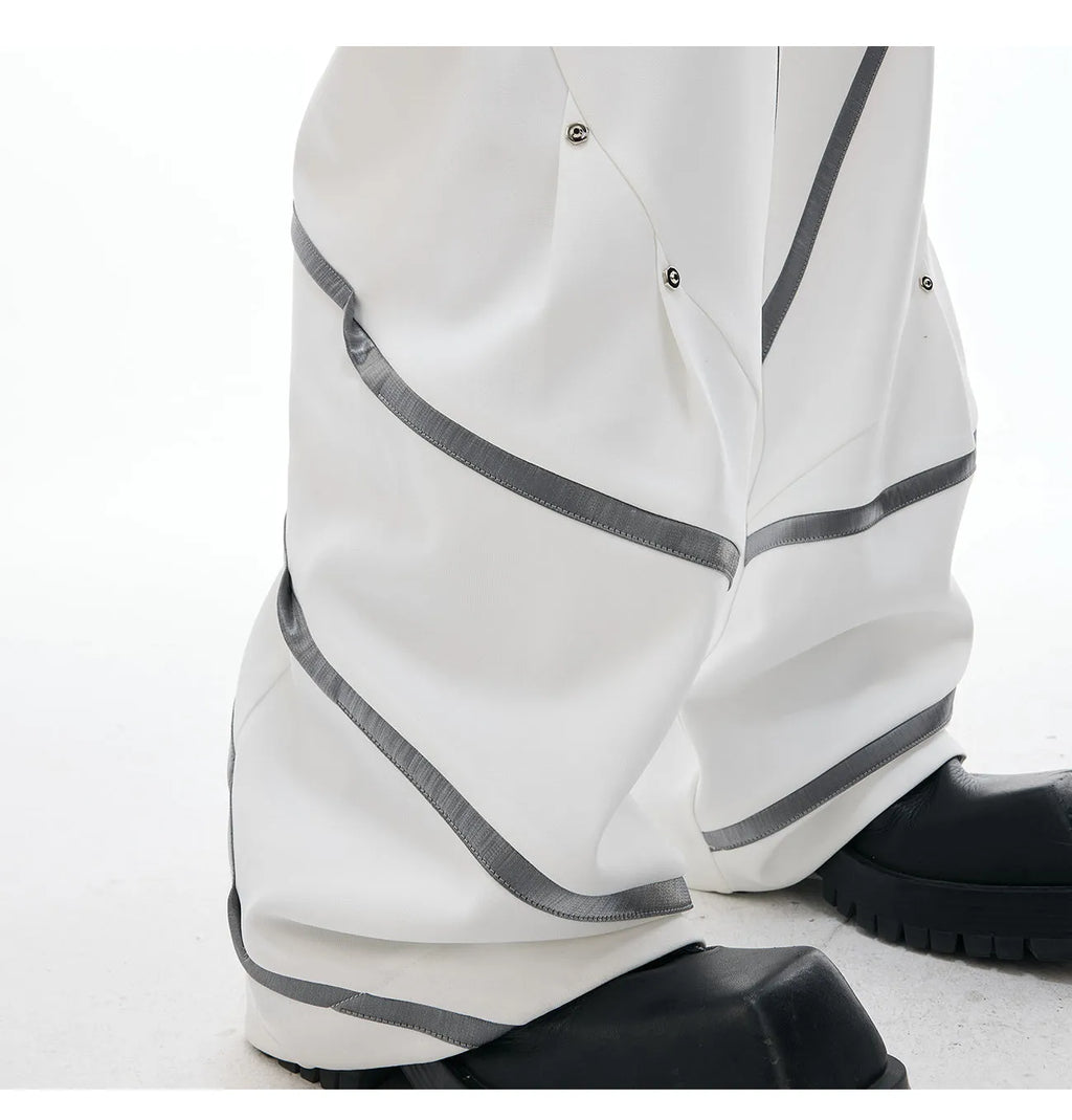 Men's grey polyester trousers with metal rivet stripes, front pleats, and a 3D cut, shown in sizes S to XL.