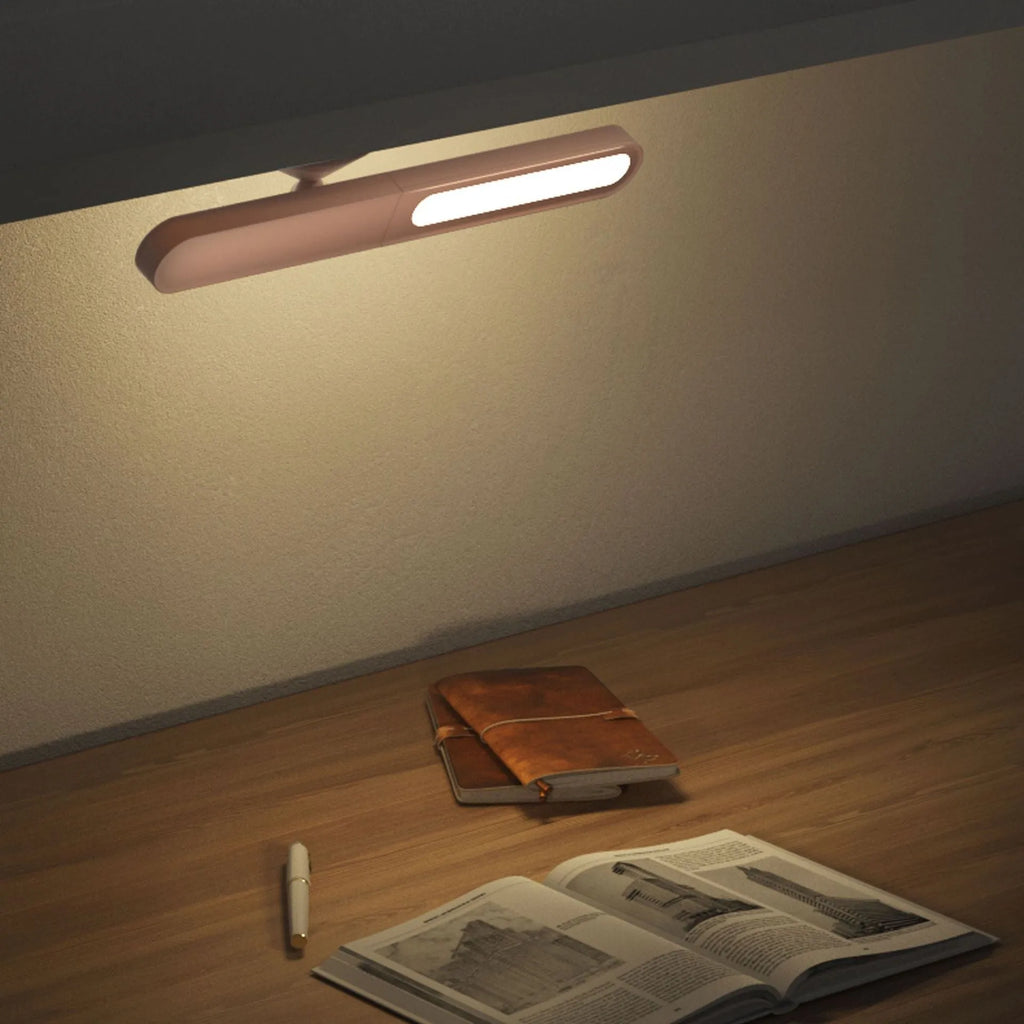 Geometric design table lamp with magnetic base on desk next to USB cable