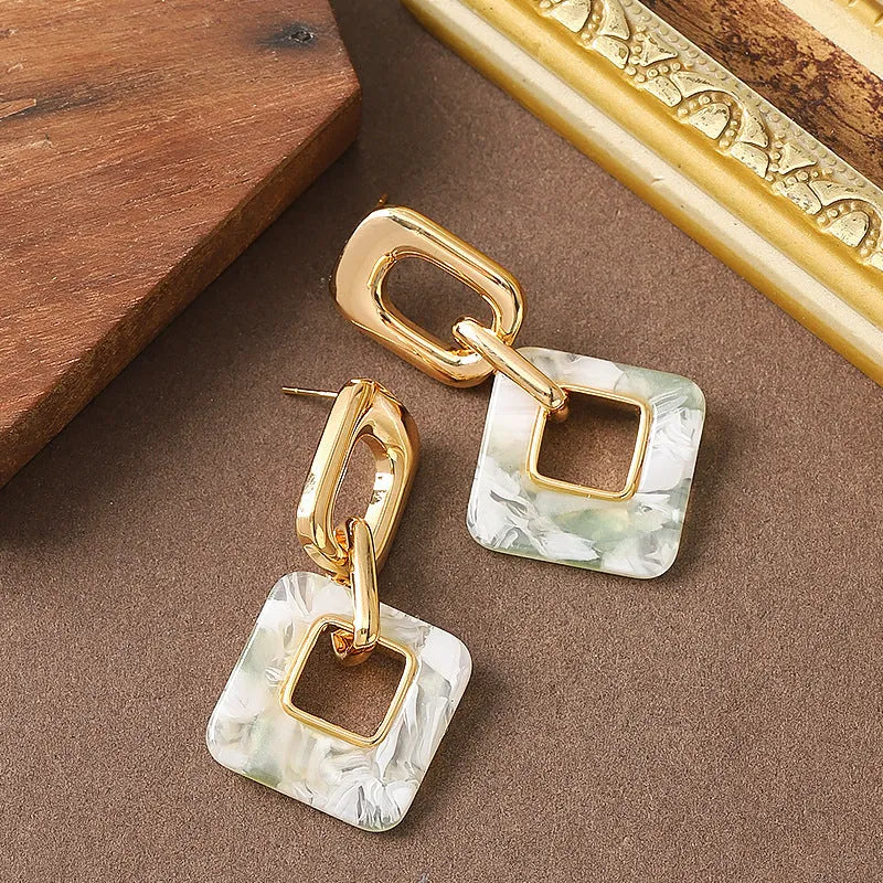 A pair of hollow geometric square earrings with chamfered corners, made from electroplated copper.