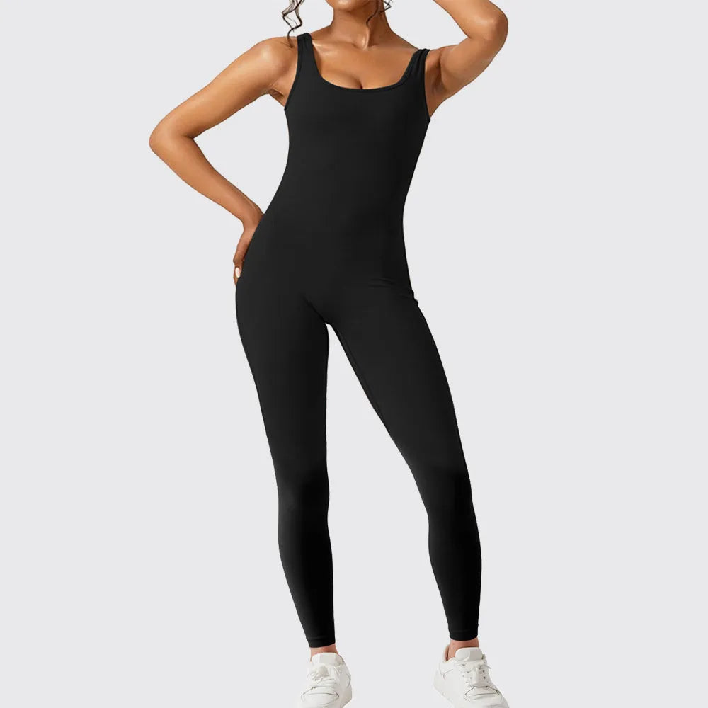 Woman wearing a sleeveless army green flare jumpsuit for yoga or fitness.