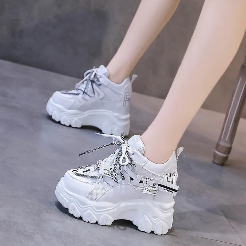 Women's white low-top platform tennis shoes with mesh upper and cross-strap detail on a rubber sole.