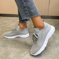 Women's Flyknit mesh running shoes in creamy white colour showing low-top slip-on design and rubber sole.