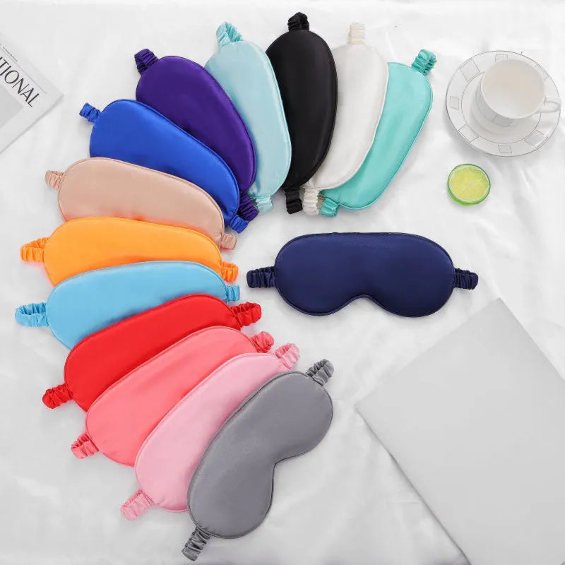 Double-sided rayon elastic satin sleep eyeshade mask in a selection of colours on a white background.