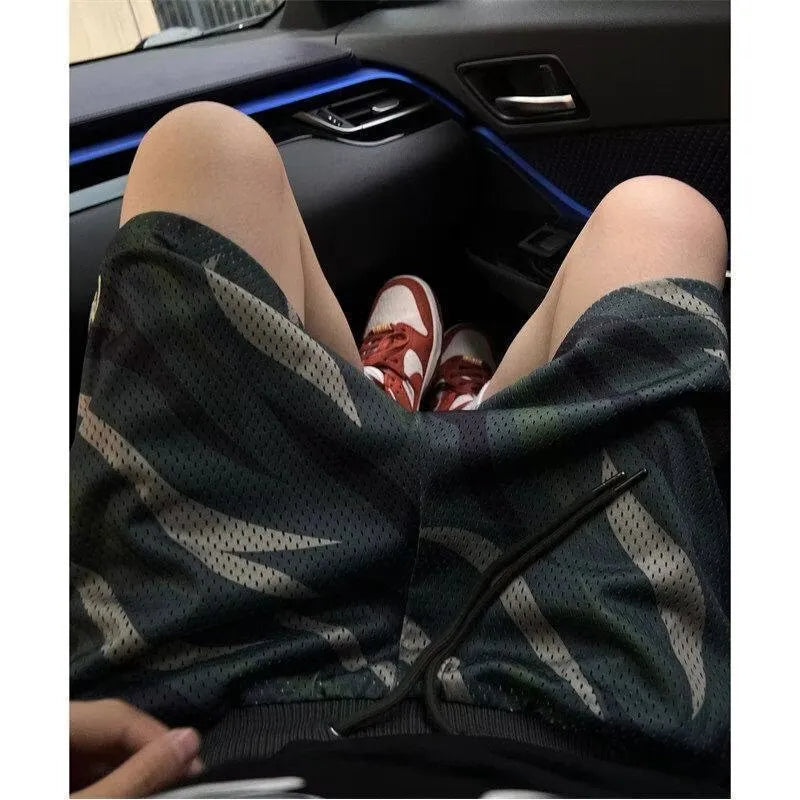 Men's straight-leg camouflage shorts in cotton blend fabric on a plain background