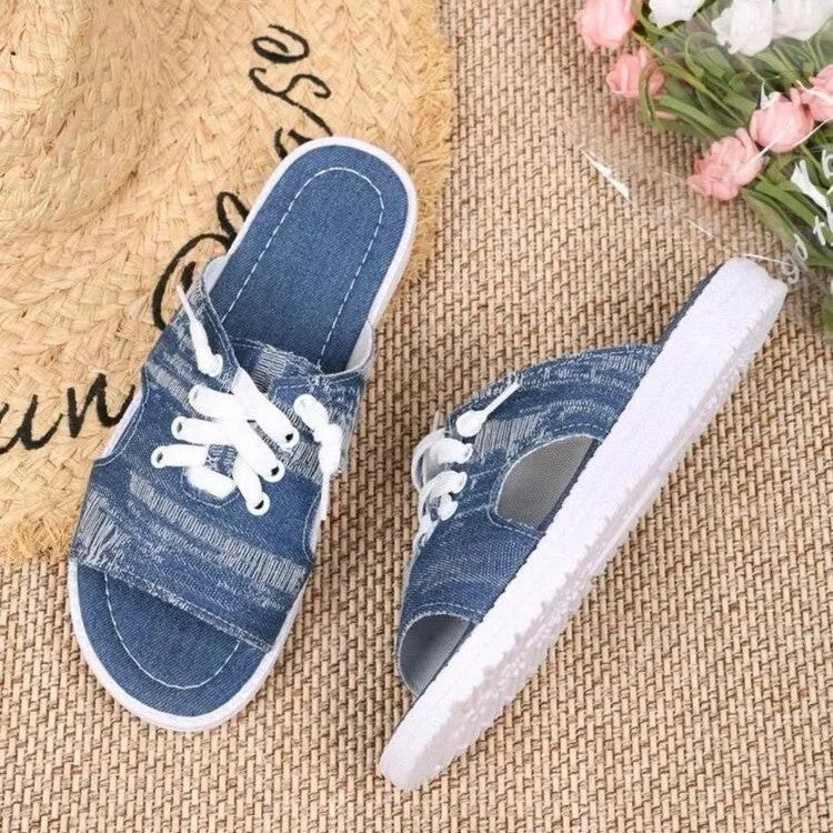 Blue Roman-style women's flat canvas slippers with cloth upper and rubber sole.
