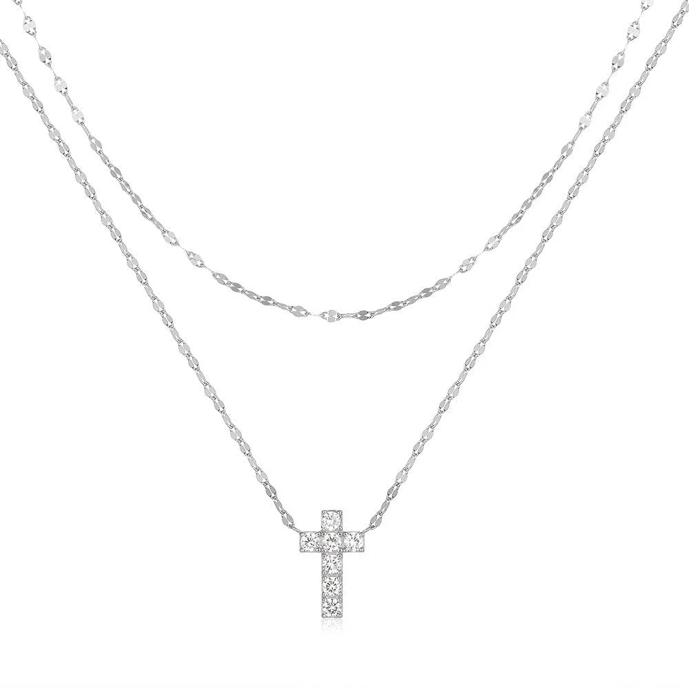 Close-up of a double-layer sterling silver cross pendant on a clavicle chain, available in gold and white gold finishes.