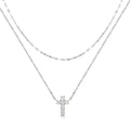 Close-up of a double-layer sterling silver cross pendant on a clavicle chain, available in gold and white gold finishes.