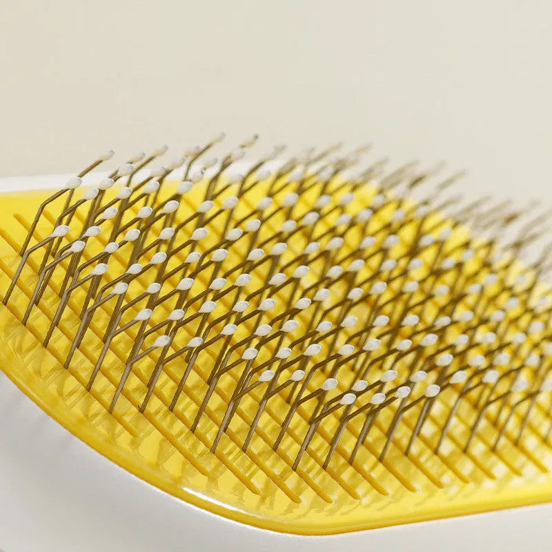 Grey capsule cat dog grooming comb with stainless steel needles on surface