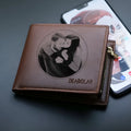 Men's leather wallet with a zipper closure, presented as a gift.