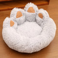 Round plush pet bed in coffee colour with raised rim and textured hand-shaped brush nest surface