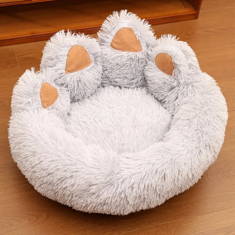Round plush pet bed in coffee colour with raised rim and textured hand-shaped brush nest surface
