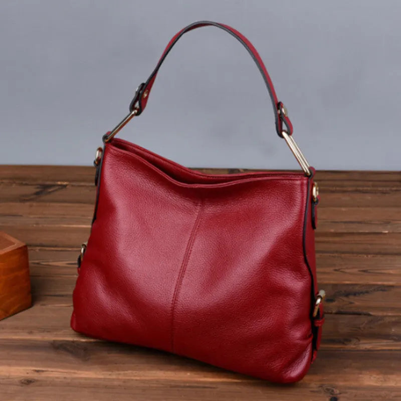 Genuine leather vertical square crossbody bag in black, showing front sandwich pocket and sewing line details.