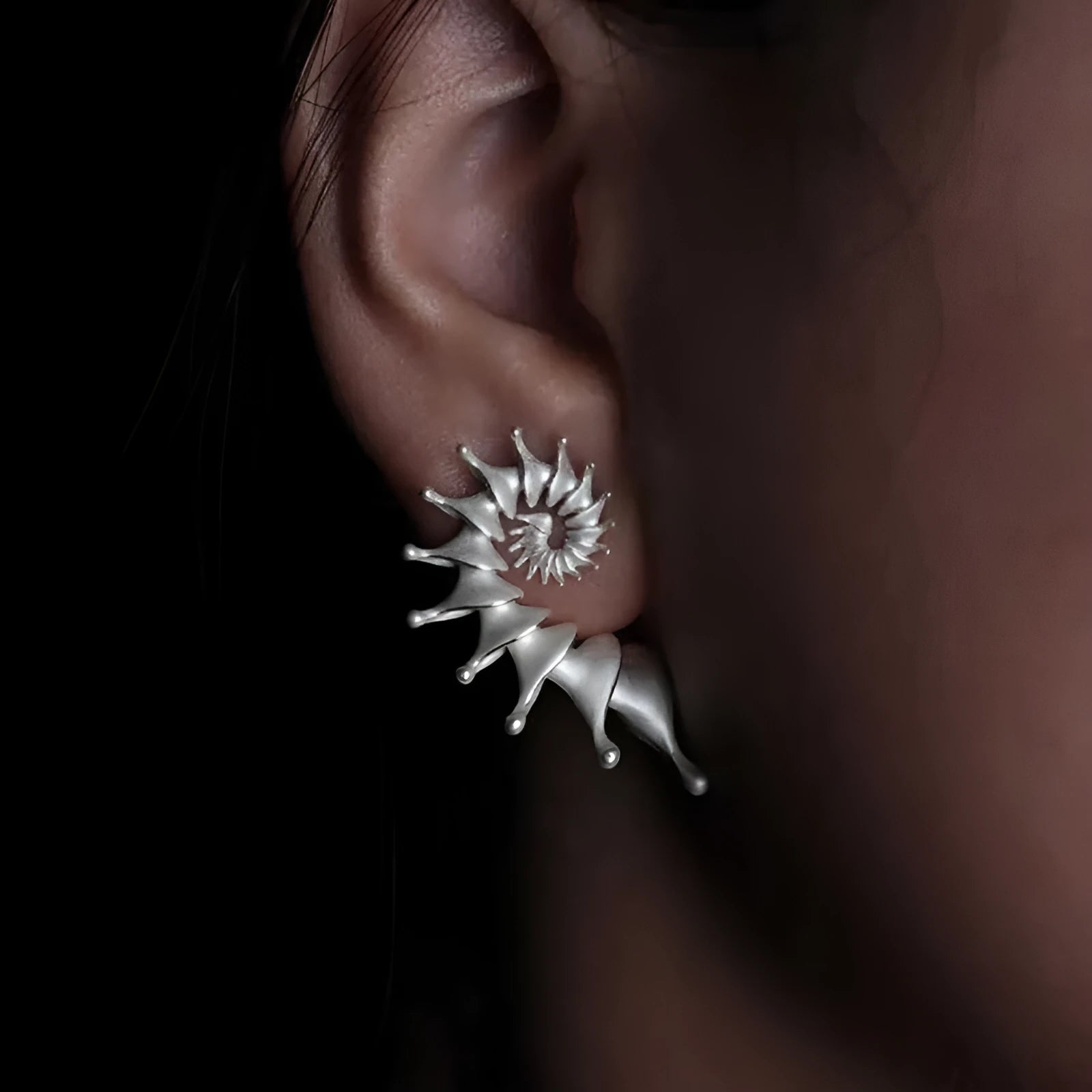 A pair of three-dimensional matte finish conch shell stud earrings in alloy with irregular shaping.