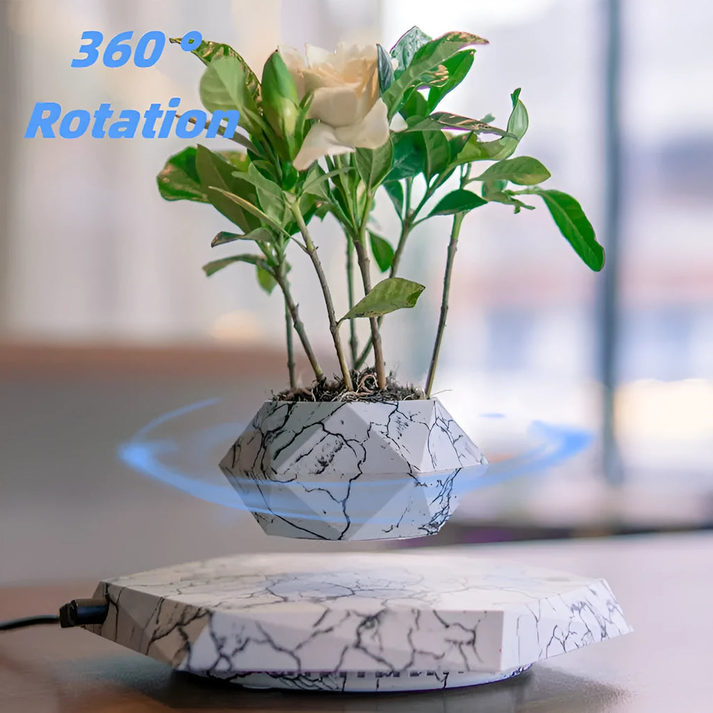 Small marble-colour magnetic levitating plant pot rotating above its base