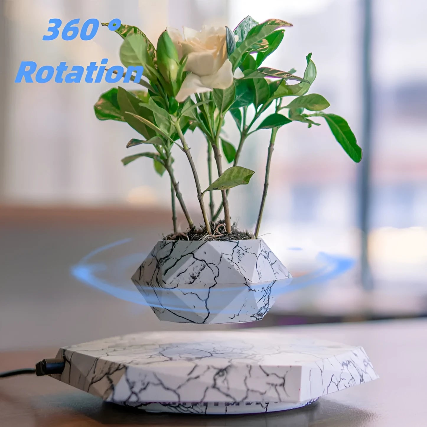 Small marble-colour magnetic levitating plant pot rotating above its base