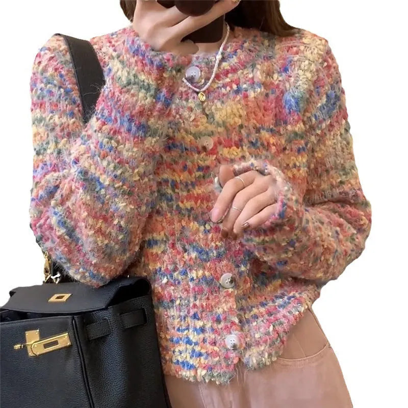 Pink and green retro rainbow patterned knitted cardigan sweater on a hanger.