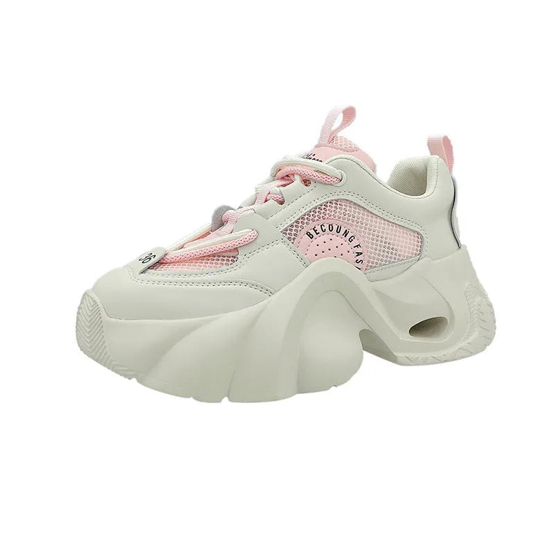 Women's pink platform sneakers with a thick sole and cross ankle straps on a white background.