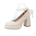 Women's beige Mary Jane shoes with chunky heel and ankle strap buckle on a wooden floor.