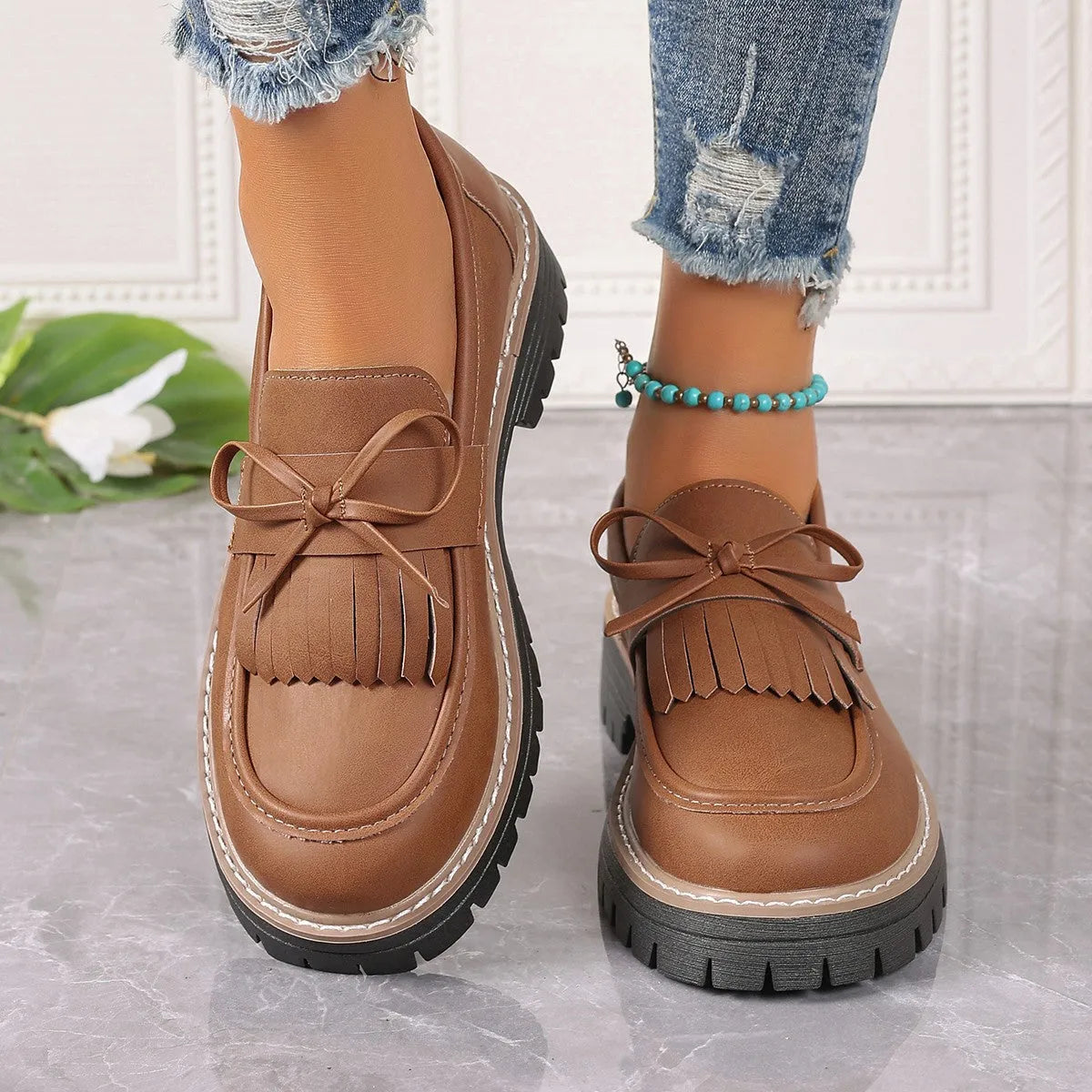 Plus size black women's loafers with tassel detail, bowknot, and a chunky rubber sole.