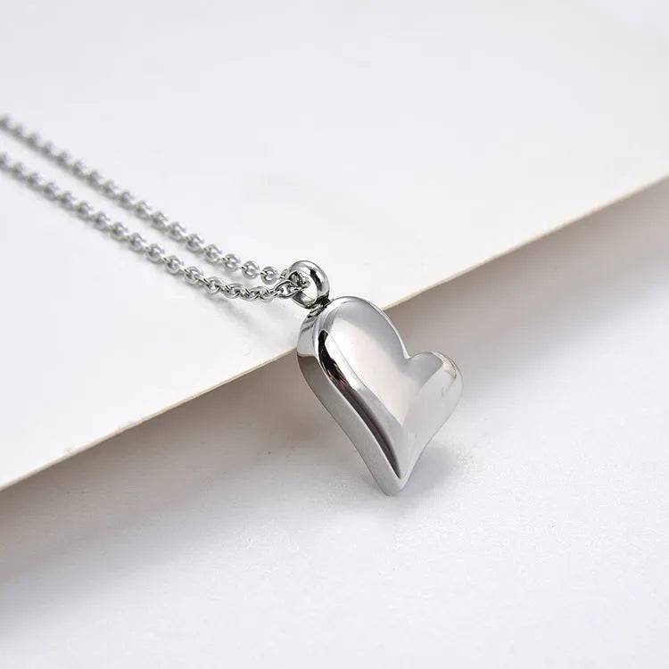 Silver curved peach heart pendant necklace on stainless steel chain with extension