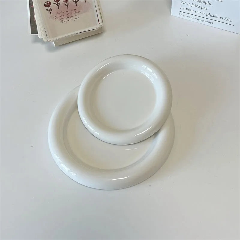 White ceramic plate with black hand-drawn doodle design, shown in bear and round patterns.