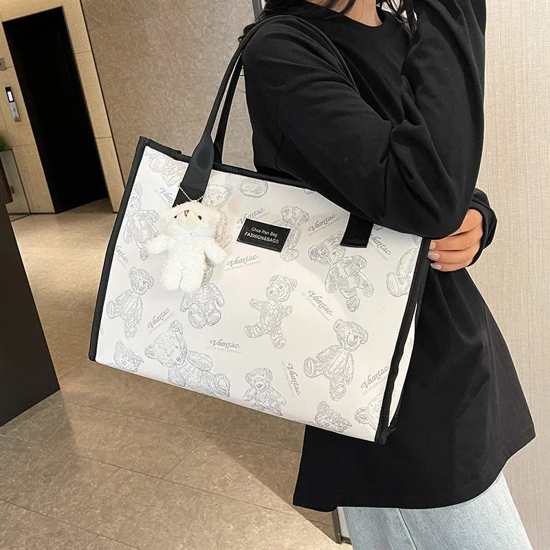 Women's printed canvas tote bag with diamond pattern, sandwich pocket, and shoulder strap
