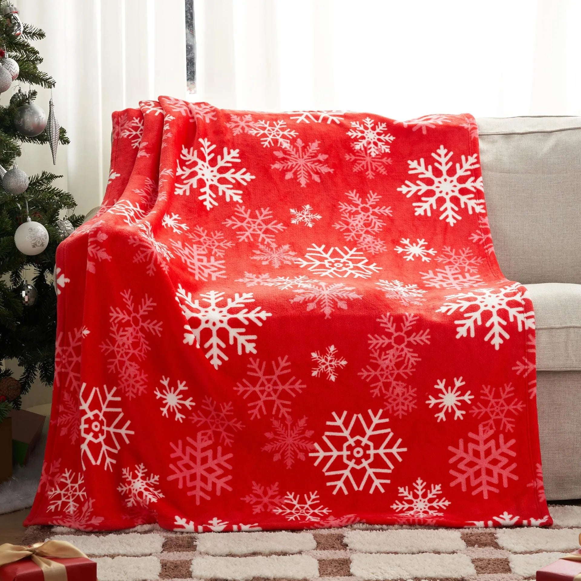 Soft flannel Christmas blanket in a plush fabric, shown in one of five available colours, draped over a sofa.