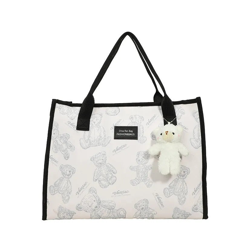 Women's printed canvas tote bag with diamond pattern, sandwich pocket, and shoulder strap