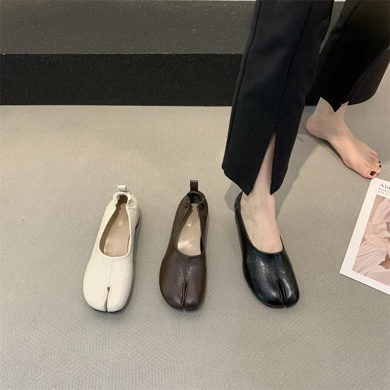 Women's black chunky heel pumps with a unique split toe horseshoe peas design and a low rubber sole.