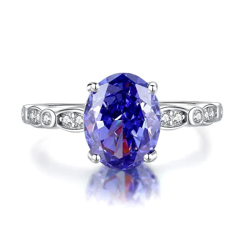 Heart-shaped 925 sterling silver ring with a sparkling ice flower cut colour zircon stone on a finger.