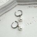 A pair of women's geometric drop earrings with a round pearl detail on alloy hooks.