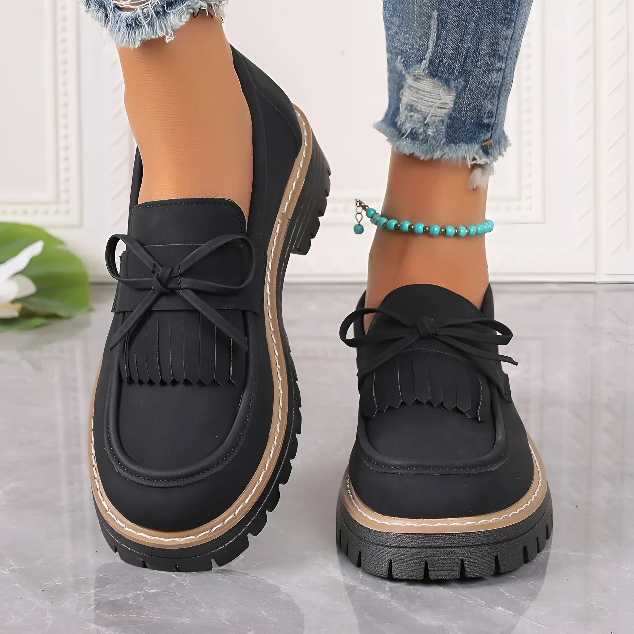 Plus size black women's loafers with tassel detail, bowknot, and a chunky rubber sole.