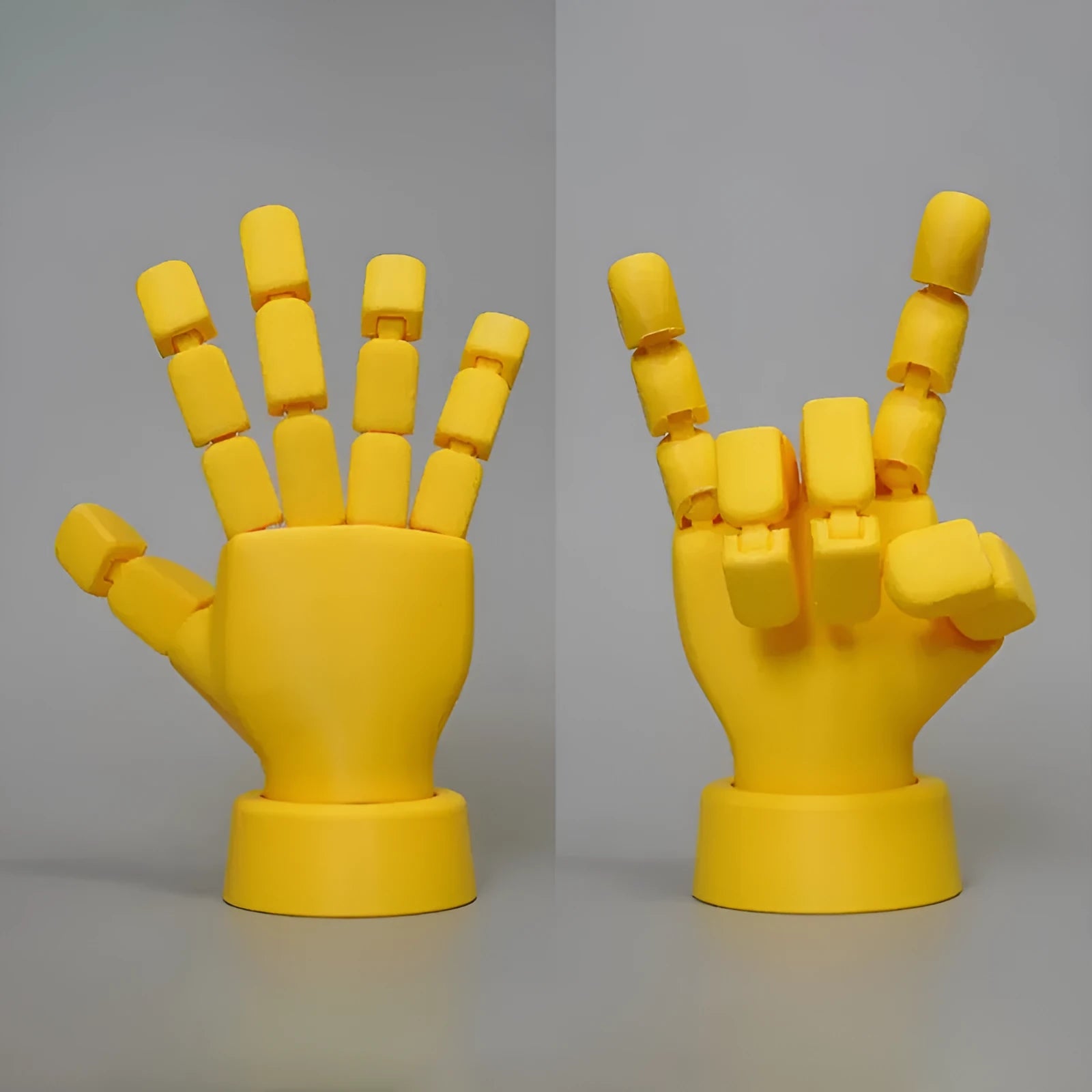 Yellow 3D printed hand prop with movable joints on a plain background.
