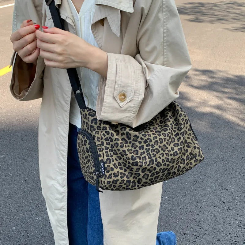 Leopard print sports style messenger bag with cross-body strap and decorative stitching