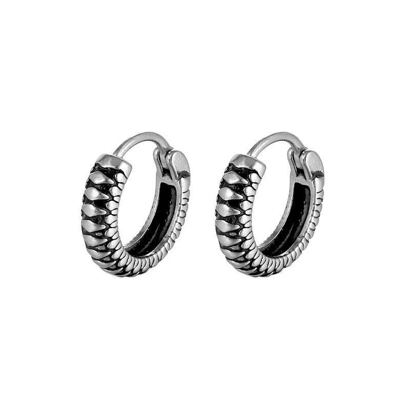 A pair of silver geometric twist earrings on a round base made from stainless steel.