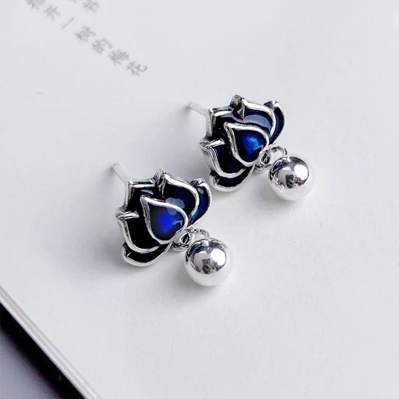 Blue alloy lotus earrings with seedpod tassel detail, showing floral stud design.