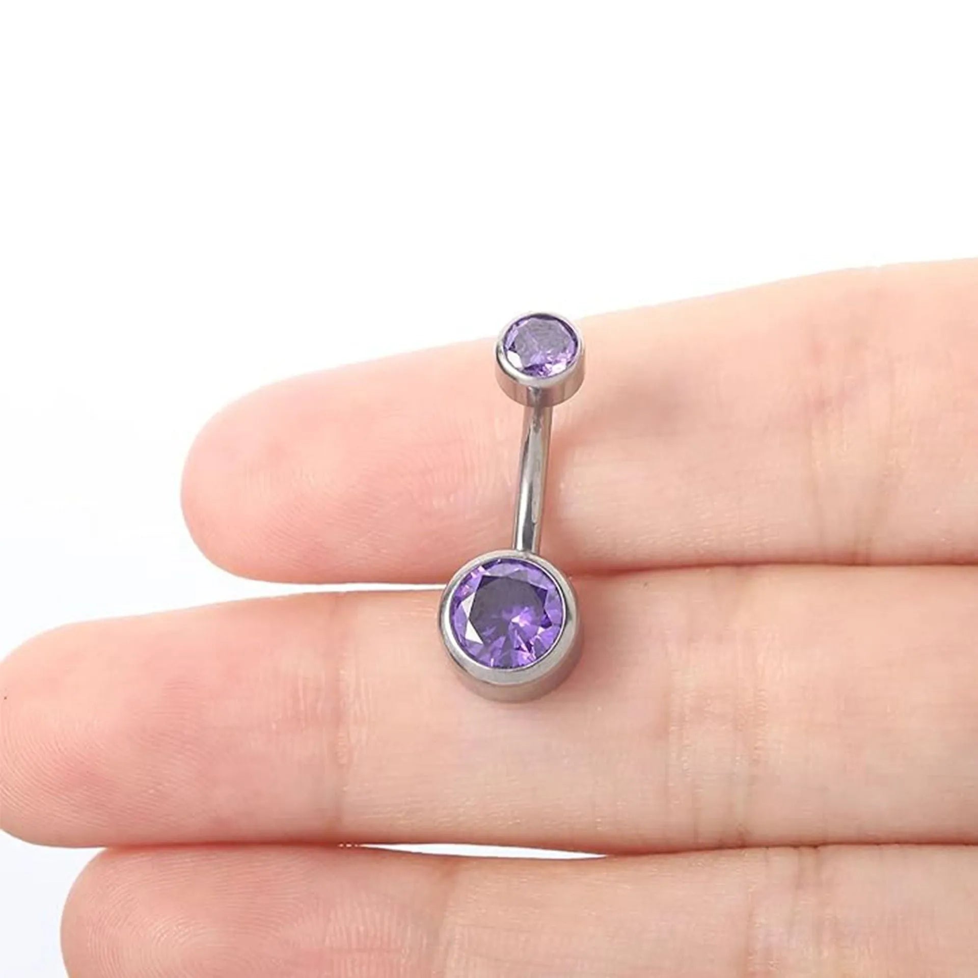 Double-headed titanium alloy navel stud with zirconium accents in various colours on a plain background.