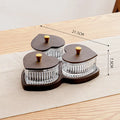 Clear glass serving platter with heart-shaped compartments and a transparent lid on a table.
