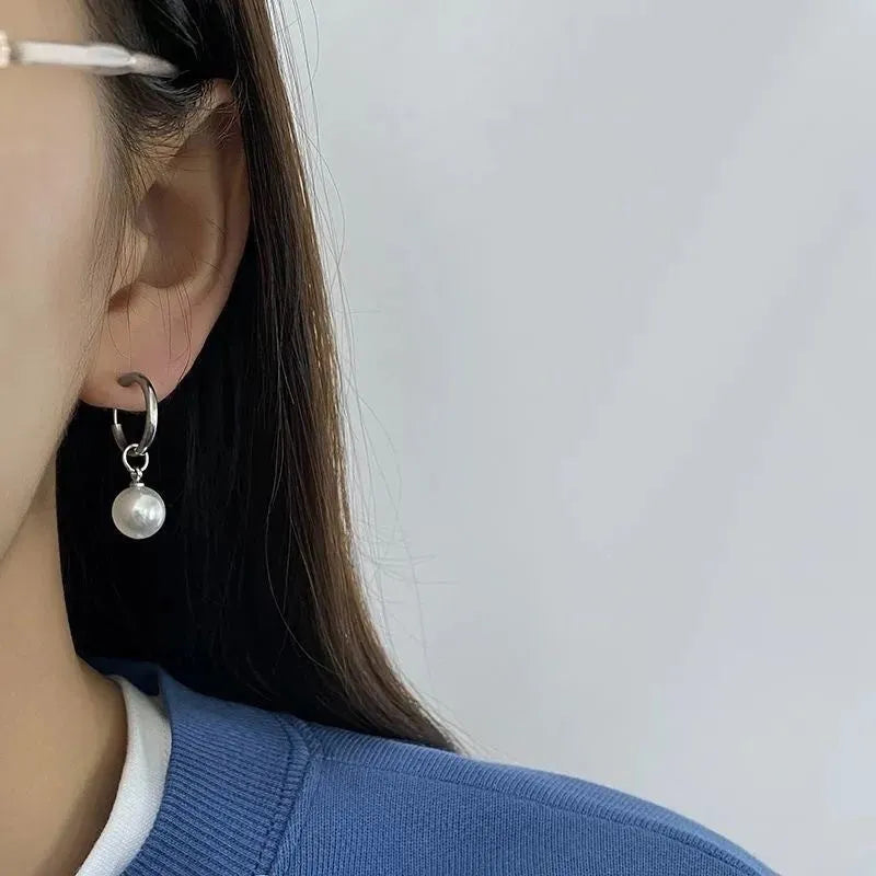A pair of women's geometric drop earrings with a round pearl detail on alloy hooks.