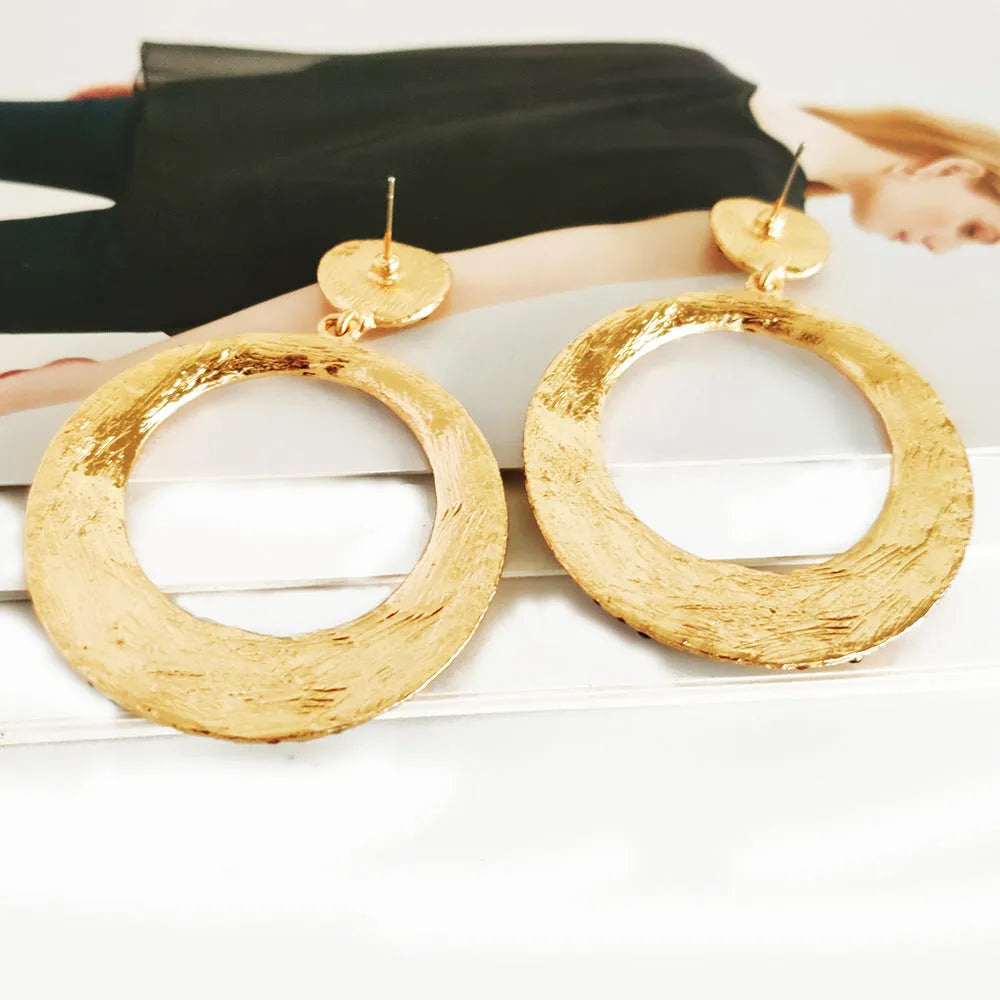 A pair of large round colourful metal pendant earrings in a cartoon style for women.