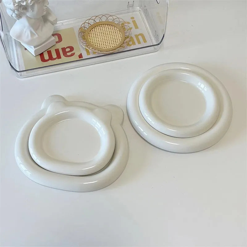 White ceramic plate with black hand-drawn doodle design, shown in bear and round patterns.