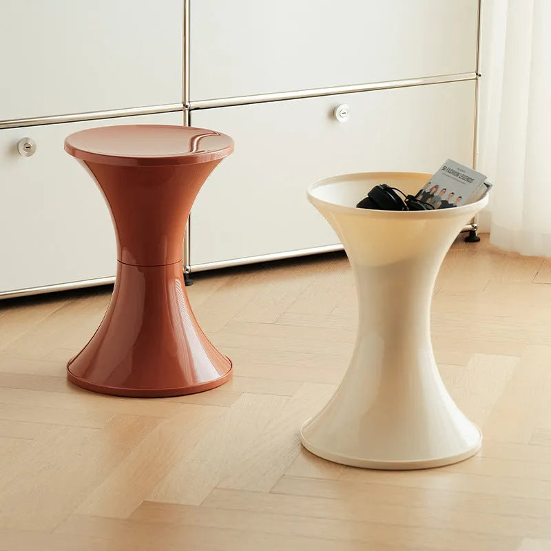 Green plastic hourglass style shoe changing stool on a wooden floor