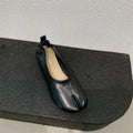 Women's black chunky heel pumps with a unique split toe horseshoe peas design and a low rubber sole.