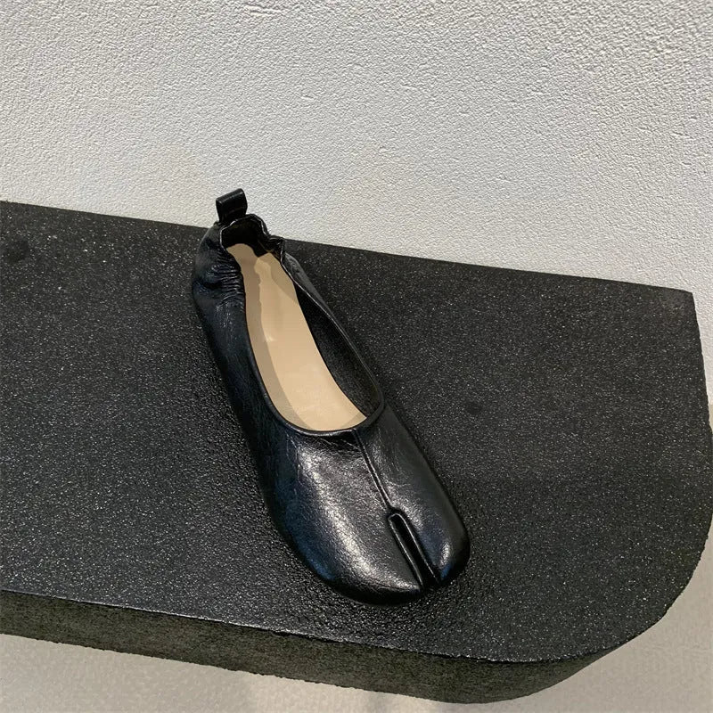 Women's black chunky heel pumps with a unique split toe horseshoe peas design and a low rubber sole.