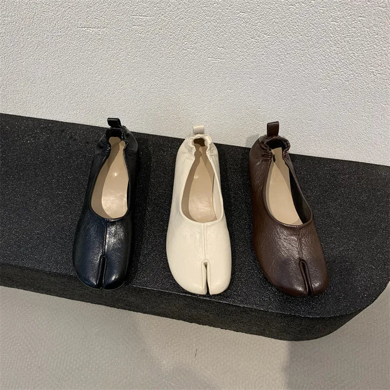 Women's black chunky heel pumps with a unique split toe horseshoe peas design and a low rubber sole.
