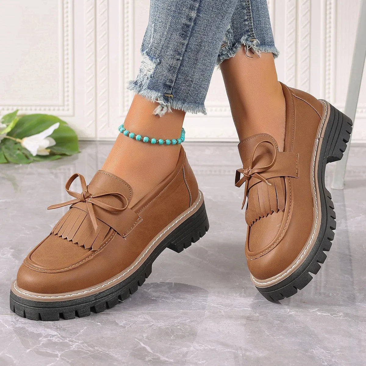 Plus size black women's loafers with tassel detail, bowknot, and a chunky rubber sole.
