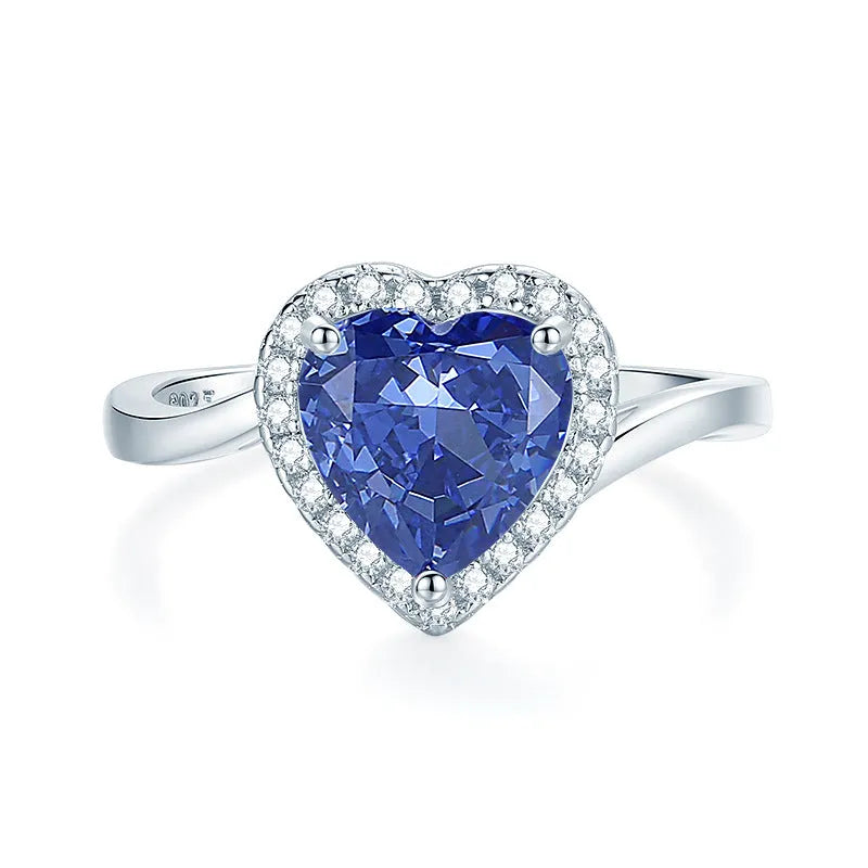 Heart-shaped 925 sterling silver ring with a sparkling ice flower cut colour zircon stone on a finger.